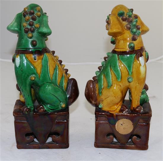 A pair of Chinese sancai glazed figures of Buddhist lions seated on plinths, 19th/20th century, 25cm